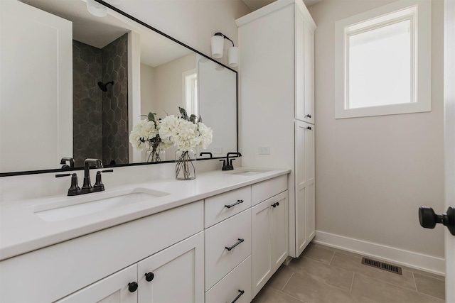 703 Richland Ct, Van Meter, IA 50261 - bathroom with double vanity, tile patterned flooring, and tiled shower