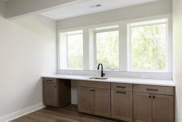 703 Richland Ct, Van Meter, IA 50261 - kitchen with wood finished floors, light countertops, and decorative backsplash