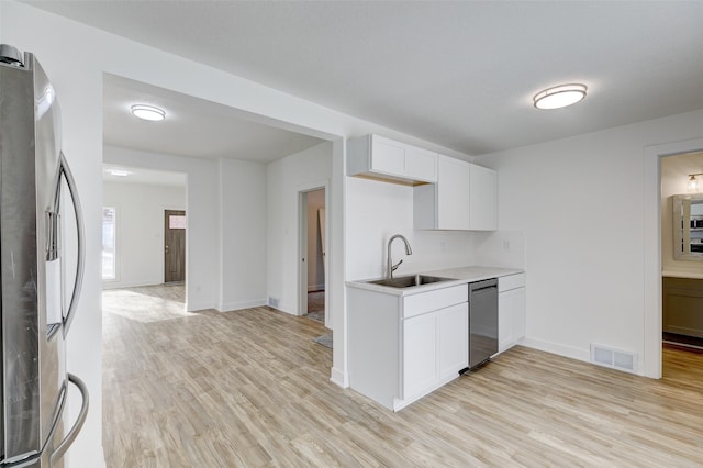 kitchen featuring white cabinetry, stainless steel appliances, sink, and light hardwood / wood-style flooring