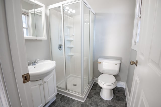 bathroom featuring toilet, walk in shower, and sink