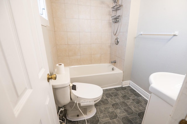 bathroom with toilet and tiled shower / bath