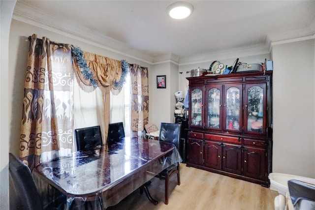 dining room with light wood-type flooring and ornamental molding