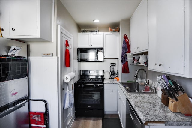 kitchen featuring light stone countertops, sink, dark wood-type flooring, white cabinets, and black appliances