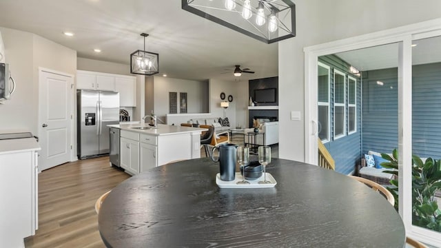 dining room with recessed lighting, a fireplace, ceiling fan, and wood finished floors