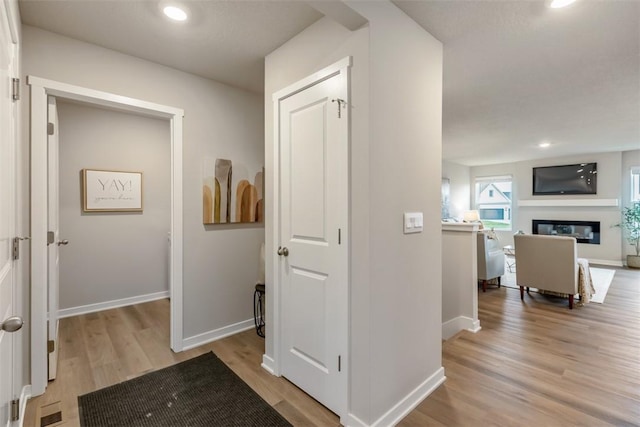 corridor with recessed lighting, light wood-type flooring, and baseboards