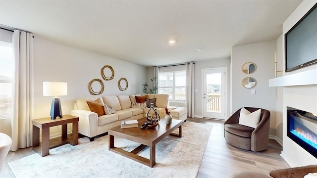 4772 172nd St, Urbandale, IA 50323 - living area featuring a glass covered fireplace and light wood finished floors