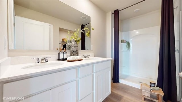 4772 172nd St, Urbandale, IA 50323 - full bath featuring double vanity, a shower with curtain, and wood finished floors