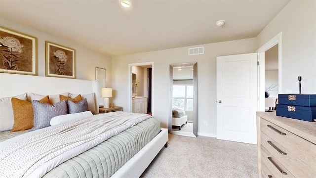 bedroom featuring connected bathroom and light colored carpet