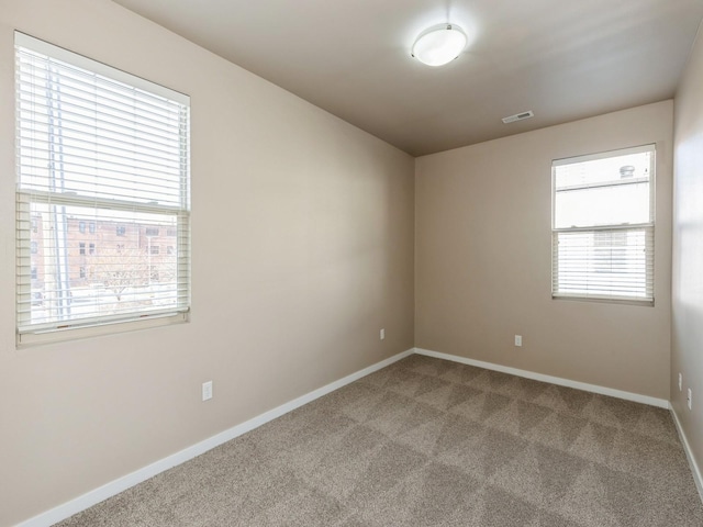 carpeted spare room featuring a wealth of natural light