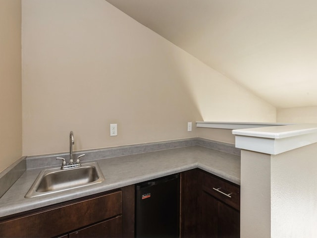 kitchen featuring black dishwasher, dark brown cabinetry, vaulted ceiling, and sink