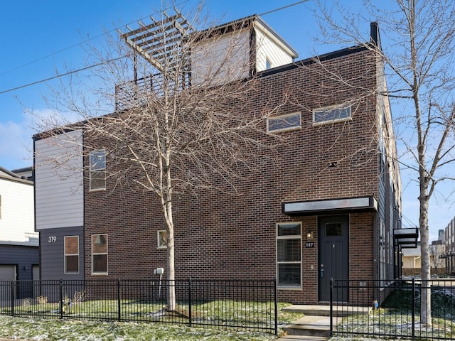 319 SW 7th St Unit 107, Des Moines, IA 50309 - view of front of property featuring a chimney, brick siding, and a fenced front yard