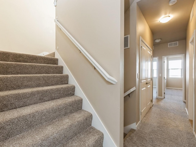 319 SW 7th St Unit 107, Des Moines, IA 50309 - staircase featuring carpet