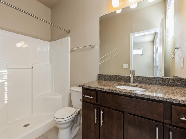 bathroom featuring tile patterned floors, toilet, vanity, and walk in shower