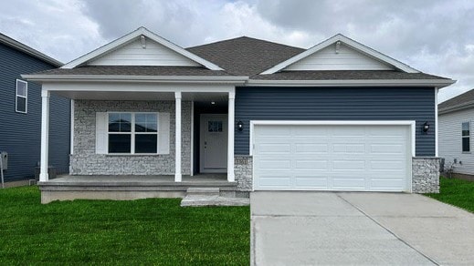 view of front of house featuring a front lawn, a garage, and covered porch