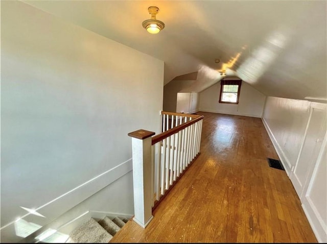 additional living space with vaulted ceiling and hardwood / wood-style flooring