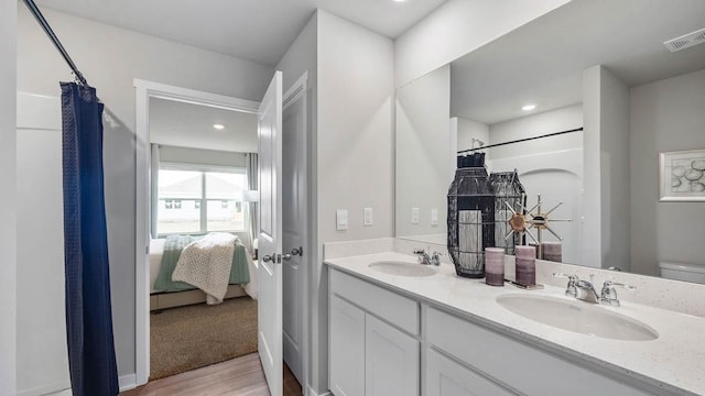 bathroom with toilet, vanity, curtained shower, and hardwood / wood-style floors