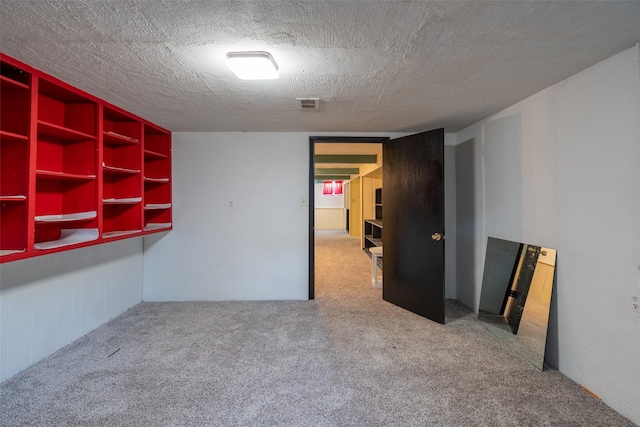 carpeted empty room with a textured ceiling