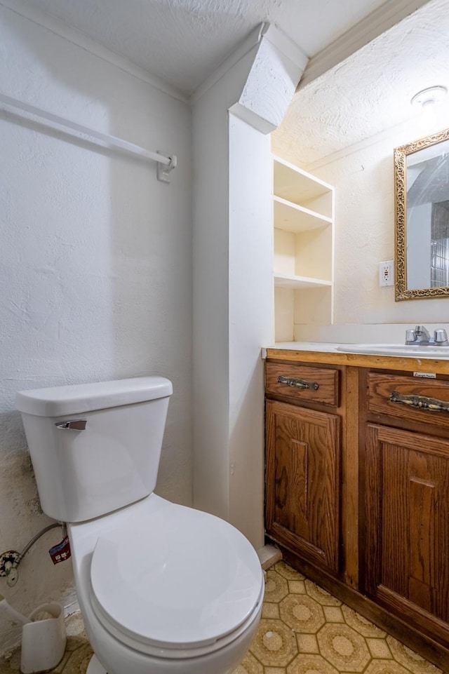 bathroom with vanity, toilet, and built in shelves