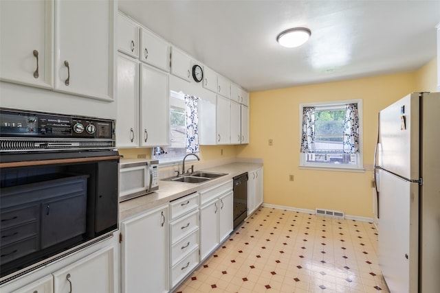 kitchen with black appliances, white cabinets, and sink