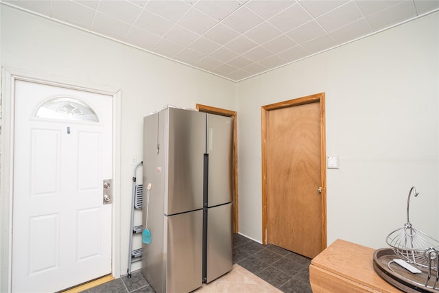 kitchen featuring dark tile patterned floors and stainless steel refrigerator