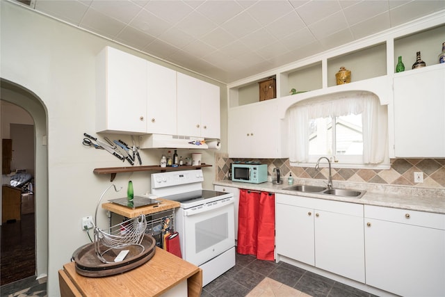 kitchen featuring dark tile patterned flooring, white appliances, white cabinetry, and sink