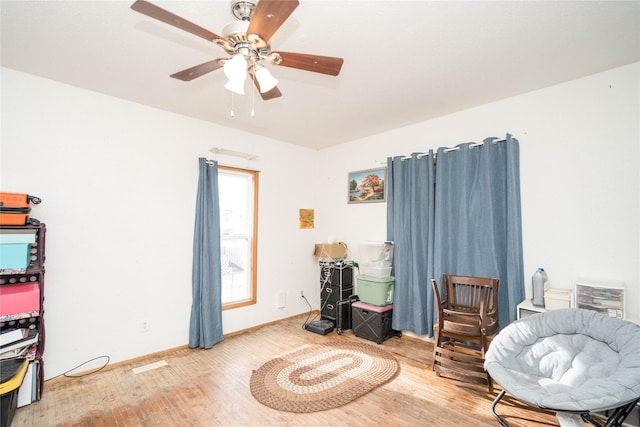 living area with hardwood / wood-style floors and ceiling fan