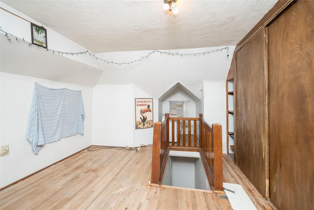 bonus room featuring a textured ceiling and light hardwood / wood-style flooring