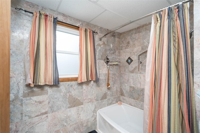 bathroom featuring shower / tub combo and tile walls