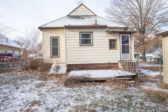 snow covered rear of property featuring a deck