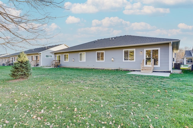 rear view of property with a yard, central AC unit, and a patio area