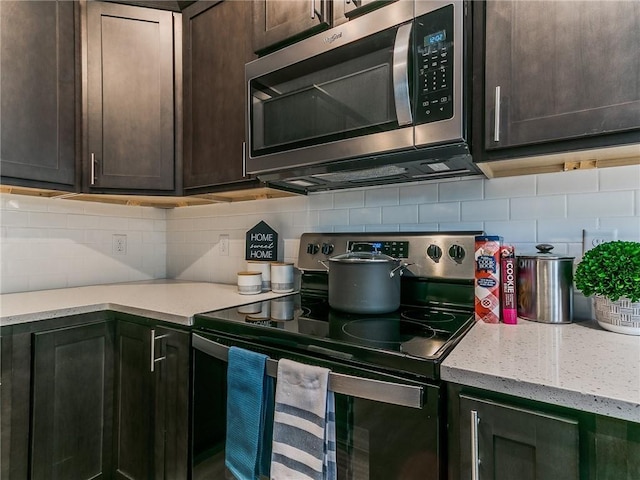 kitchen with dark brown cabinets, decorative backsplash, and appliances with stainless steel finishes