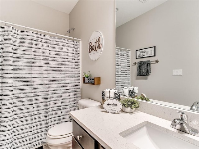 bathroom with vanity, toilet, and walk in shower