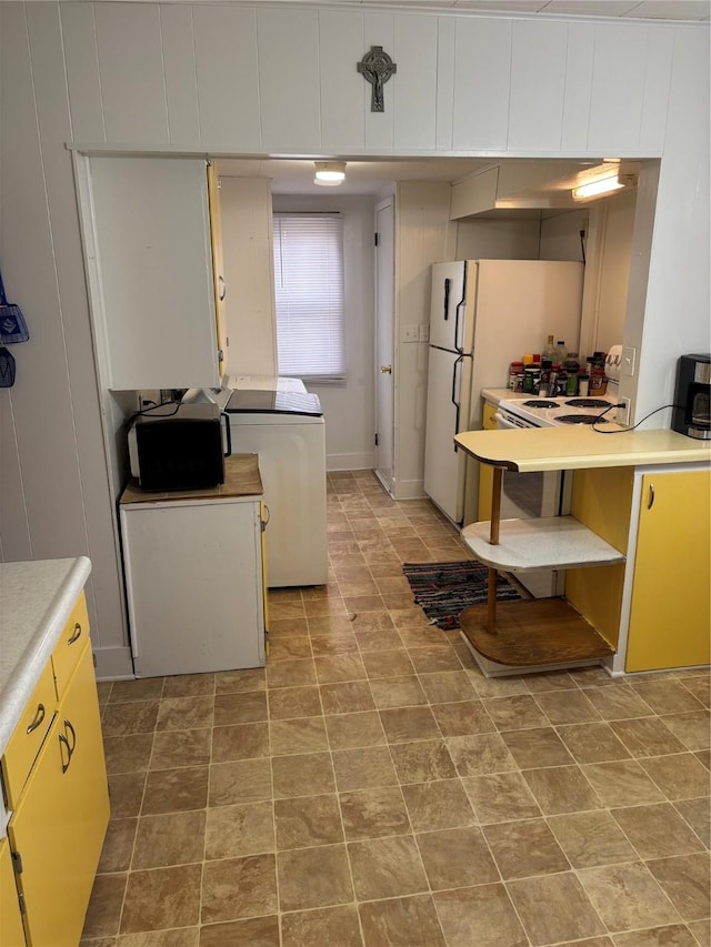 kitchen featuring white refrigerator and washer / dryer