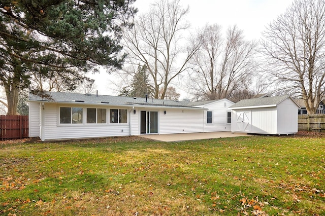 rear view of property with a yard, a shed, and a patio area