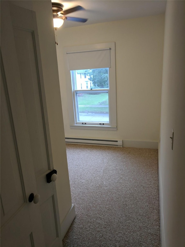 903 E St, Grinnell, IA 50112 - empty room with a baseboard radiator, carpet flooring, and ceiling fan