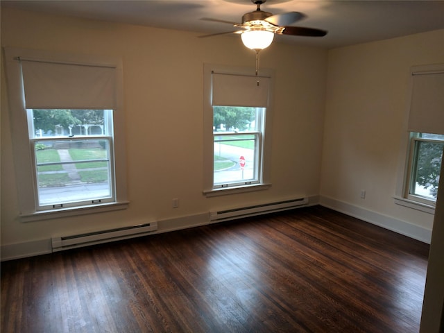 903 E St, Grinnell, IA 50112 - spare room featuring baseboard heating, a ceiling fan, and dark wood-style floors