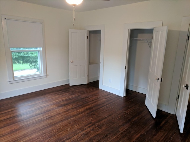 903 E St, Grinnell, IA 50112 - unfurnished bedroom with dark wood-style flooring and a closet
