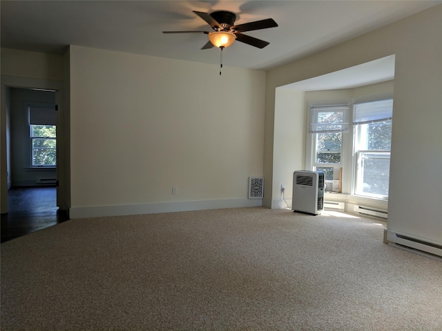 903 E St, Grinnell, IA 50112 - spare room with carpet flooring, plenty of natural light, a ceiling fan, and baseboard heating