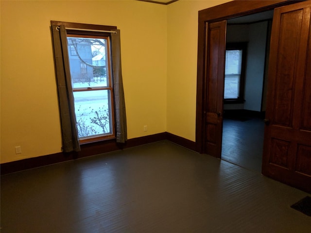 903 E St, Grinnell, IA 50112 - empty room featuring baseboards and dark wood-style flooring