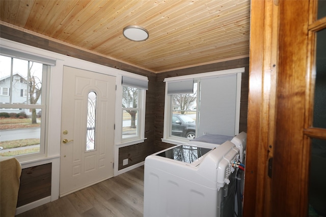 laundry area featuring light hardwood / wood-style flooring, wood walls, washer / dryer, and wooden ceiling