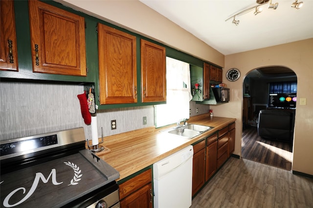 kitchen featuring dark hardwood / wood-style floors, sink, white dishwasher, and stainless steel stove