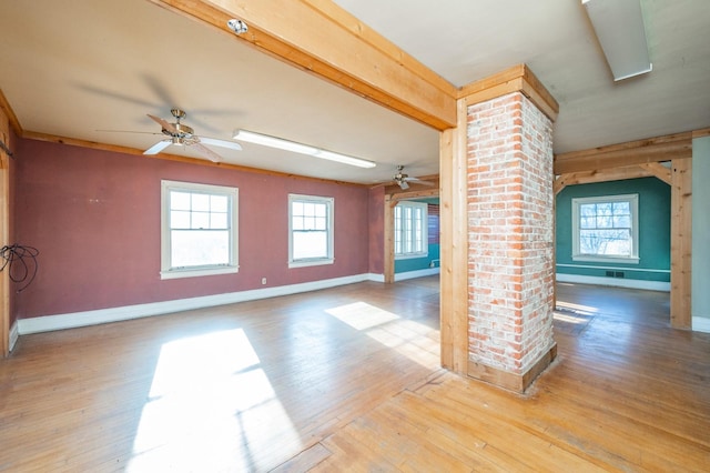 interior space with ornate columns, ceiling fan, and hardwood / wood-style flooring