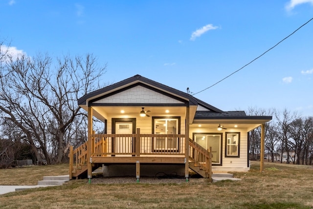 view of front of property with ceiling fan, a porch, and a yard