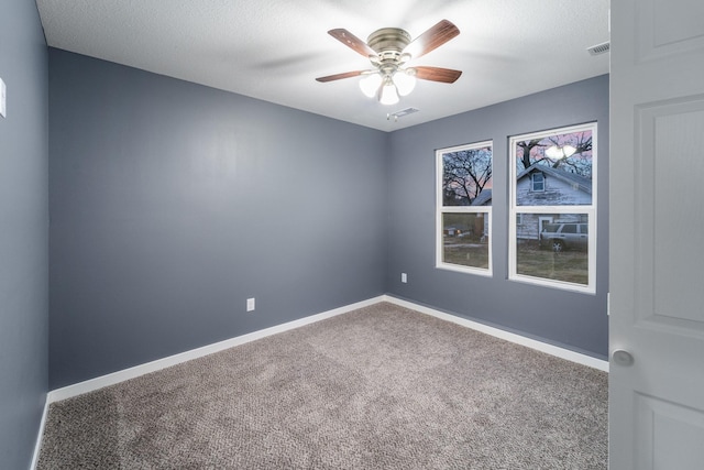 unfurnished room featuring carpet flooring, ceiling fan, and a textured ceiling