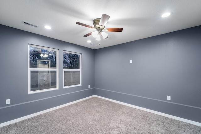 carpeted spare room with ceiling fan