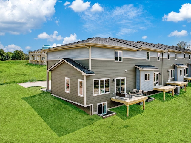 rear view of property featuring a lawn and a wooden deck