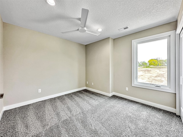 carpeted empty room with a textured ceiling and ceiling fan