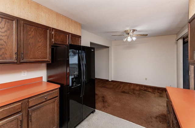 kitchen with a ceiling fan, light countertops, carpet flooring, and black fridge with ice dispenser