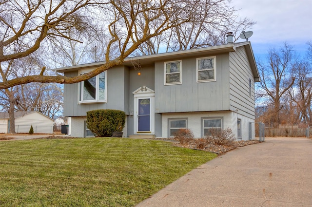 bi-level home featuring brick siding and a front yard