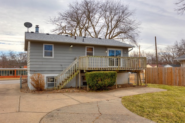 back of house featuring stairway, a yard, a deck, and fence